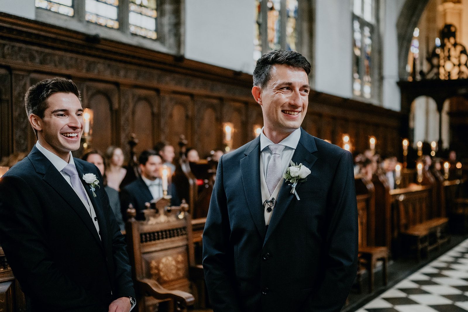 James and his best man laughing together stood at the top of the aisle of Wadham College Chapel, University of Oxford. The guests are sat in the background. Photo thanks to Matt Fox Photography.