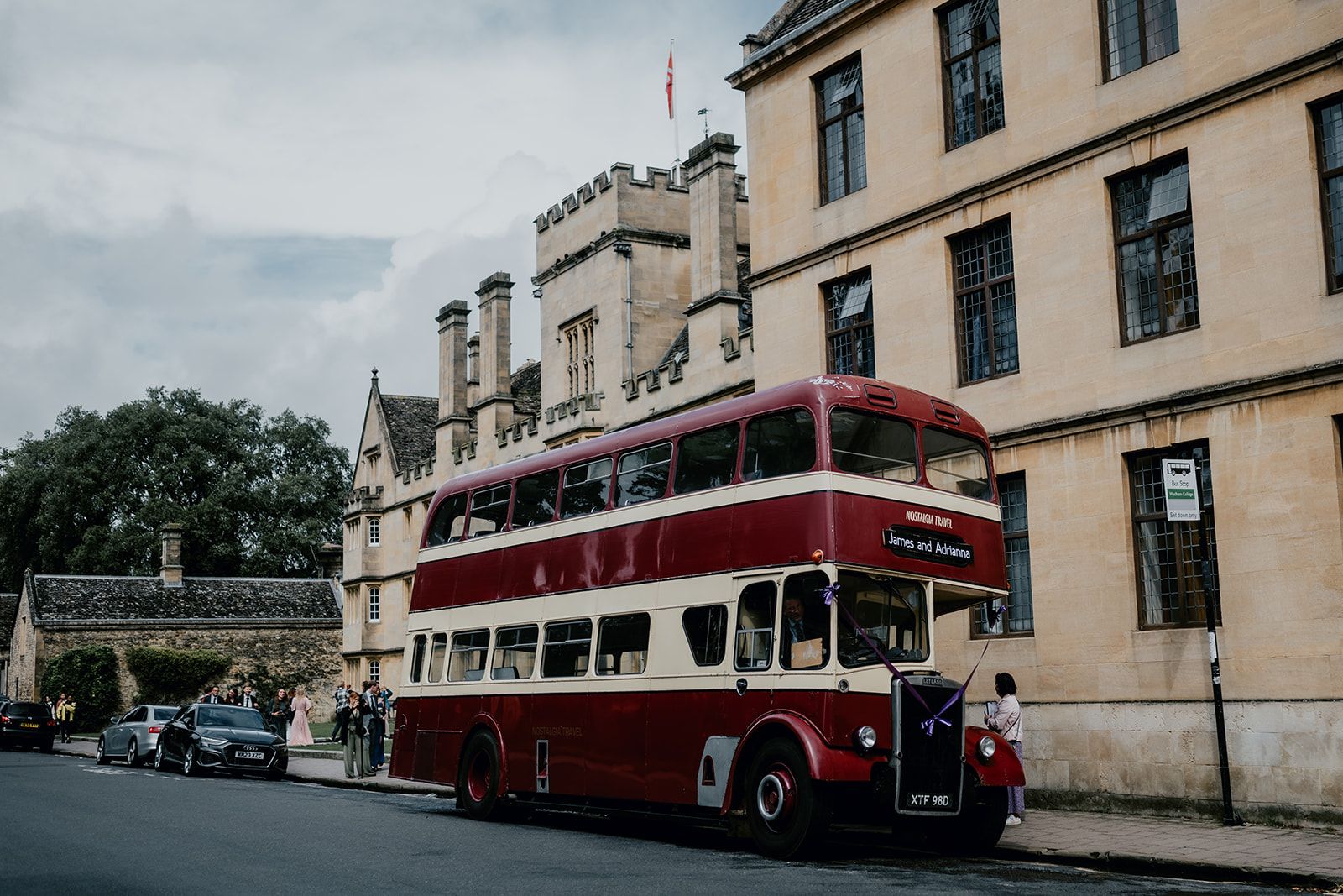 Vintage red double decker bus in front of Wadham College. Photo courtesy of Matt Fox Photography.